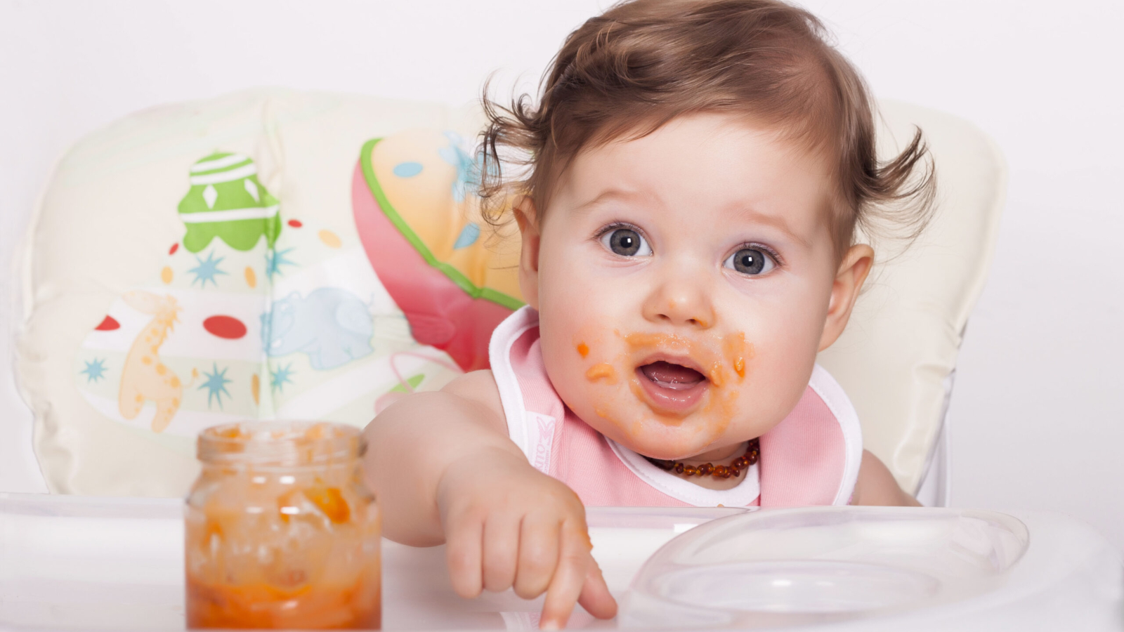 An adorable smudgy female baby eating her favorite food