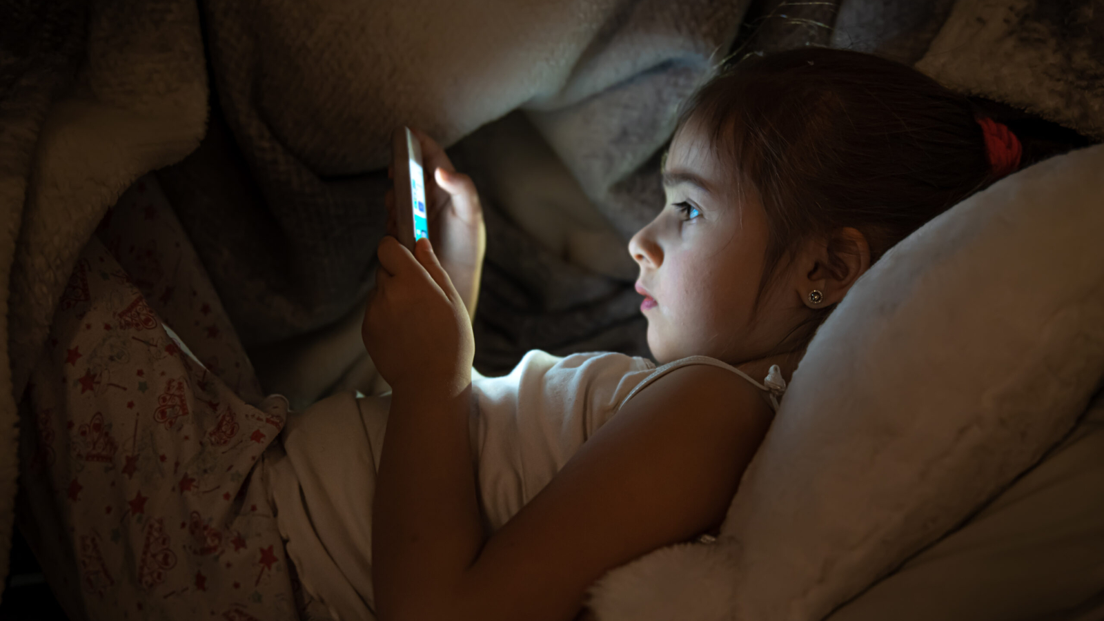 Little,Girl,Watching,Smartphone,In,Bed,,Kid,Using,Phone,And
